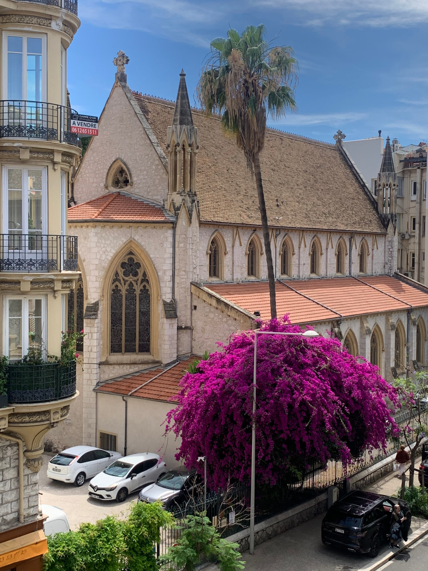 Église anglicane Holy Trinity vue depuis l'appartement, avec palmier et bougainvillier