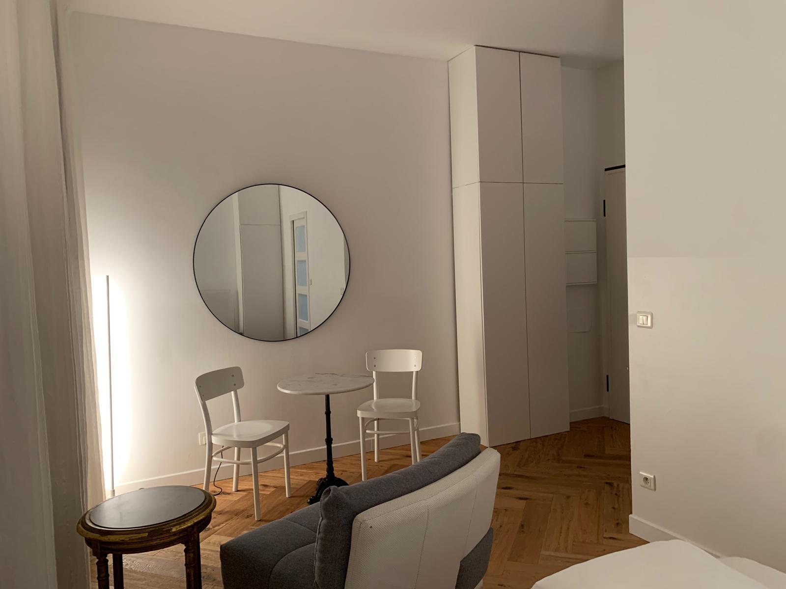 Miroir rond, table de bistrot avec chaises bistro et placards intégrés
