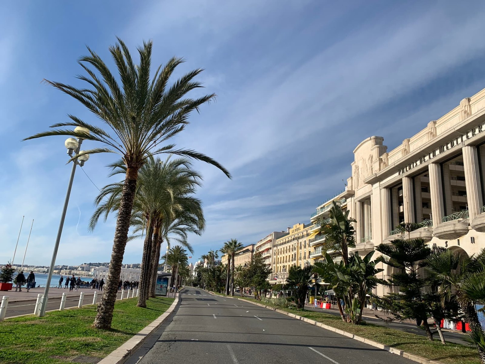 Palmiers et la Méditerranée bleue le long de la Promenade des Anglais à Nice
